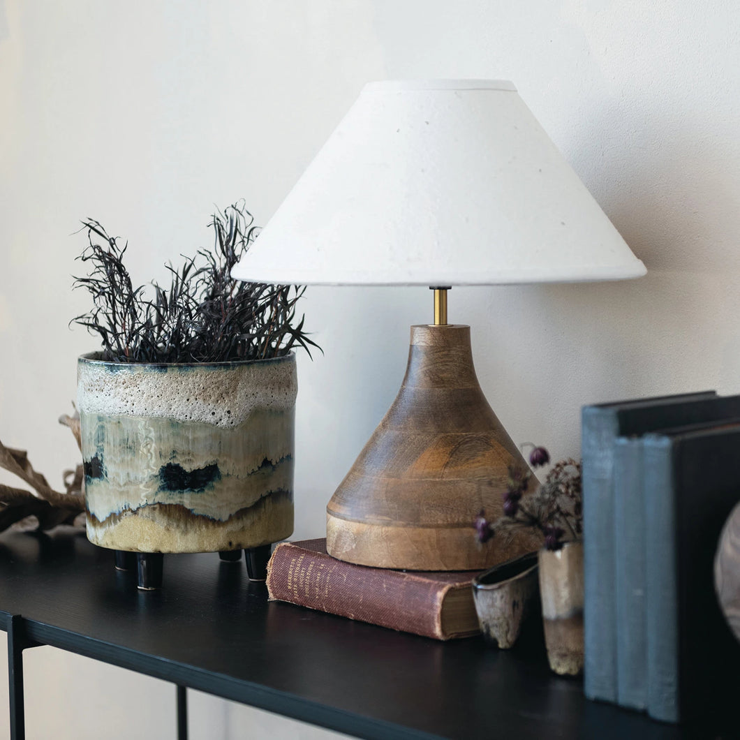 Small mango wood table lamp sitting on a console table with books and home decor