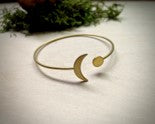 solid raw brass cuff with crescent moon detail on one end and a full moon disk on the other end.