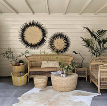 Load image into Gallery viewer, Two Usiku Woven Wall Art pieces with a natural enter and black indigo edging hanging on a wall in an outdoor lounge.
