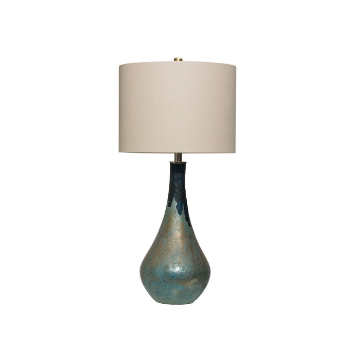 Table lamp with blue green base with an opal finish topped with a beige linen shade